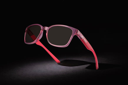 Sandy Golf Sunglasses, pink-red transparent frame with dark lenses and curved temples.
