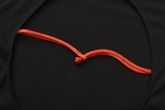 Orange drawcord tie detail on the open-back neckline of a black maxi dress