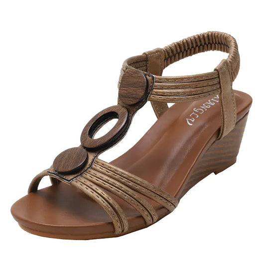 Gold Roman-style wedge sandals with wide straps, wood-look rings, and cushioned footbed