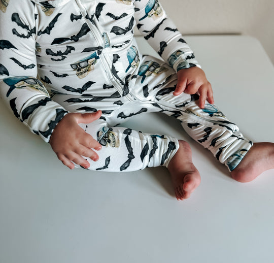 Close-up of zippy pajama legs and cuffs; white with black bats and blue skull pattern