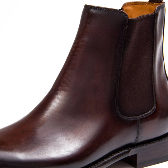 Close-up of brown Chelsea boot elastic gore and leather upper with pull-tab opening