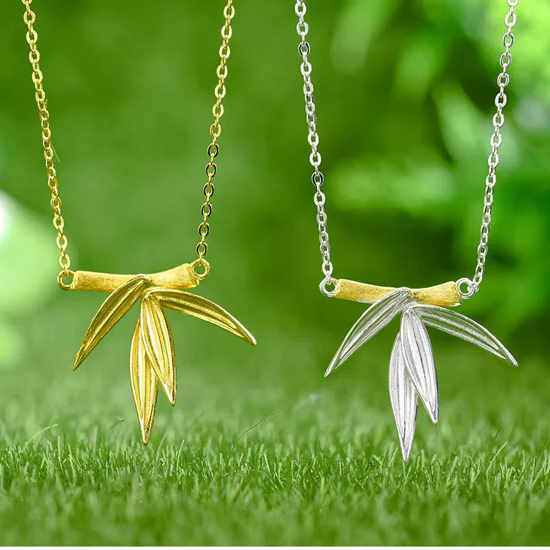 Bamboo necklace shown in gold and silver with leaf-shaped pendant on chain.