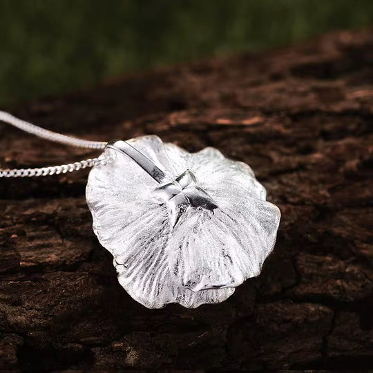 Wildflower blossom pendant side view: textured silver flower with gold center, hanging on chain