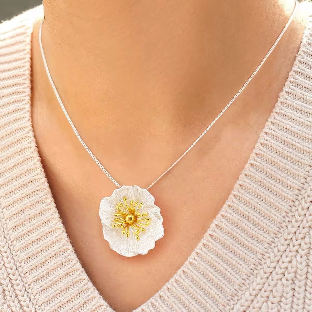 Wildflower blossom necklace on collarbone: white petal flower with gold center, silver chain
