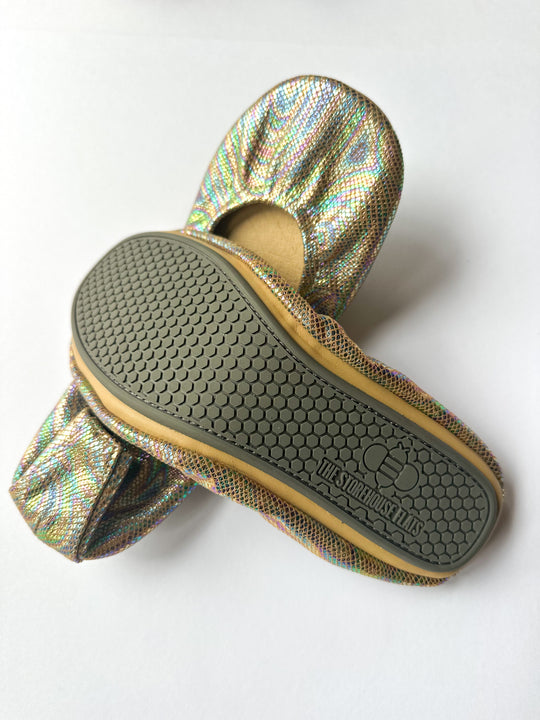Sole view: metallic iridescent flat with textured rubber outsole and brand print