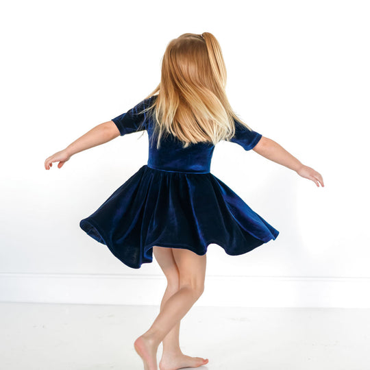 Back view: navy velvet twirl dress with gathered waist and flared skirt