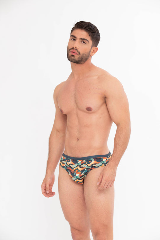 Classic swim brief with wave camouflage print, front worn, hand on hip
