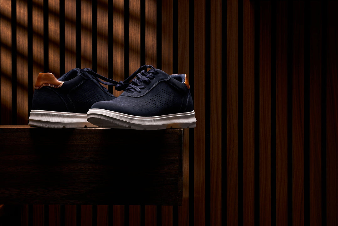 Navy lace-up walking shoes with tan heel collar and white midsole