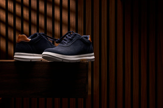 Navy lace-up walking shoes with tan heel collar and white midsole