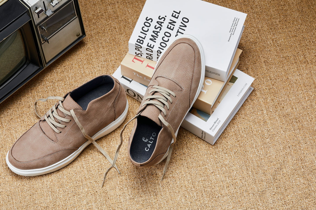 Khaki lace-up boots on floor with shoeboxes beside them