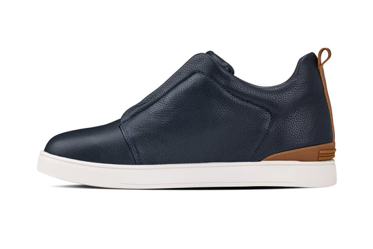 Navy slip-on sneaker side view with tan heel detail and white sole