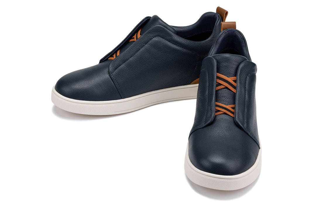 Navy slip-on sneakers with orange stripe accent and cushioned collar
