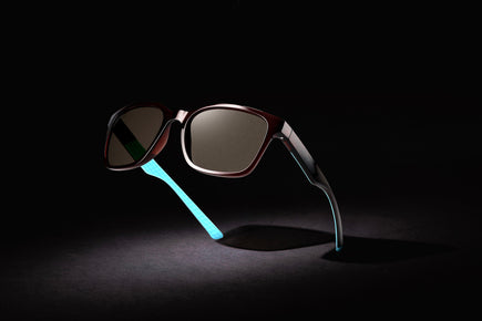 Black golf sunglasses with dark lenses and teal neon temple detail
