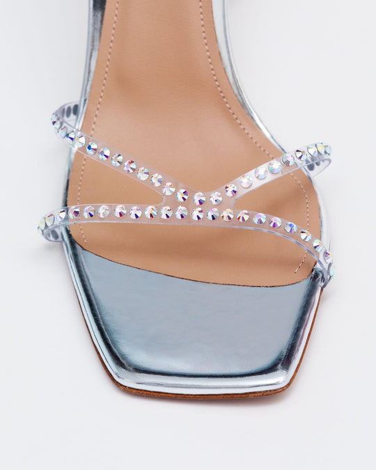 Close-up of silver crystal sandal straps with rhinestone rows across the foot