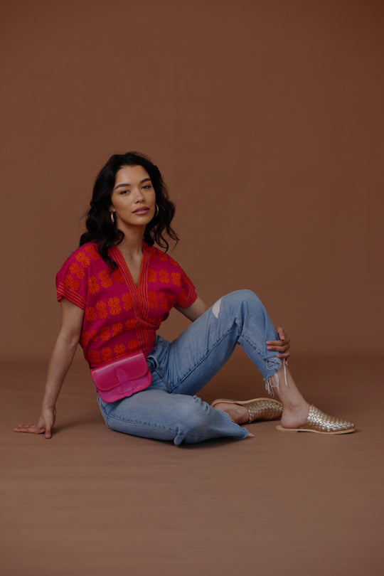 Gold woven leather slide sandals with braided upper, worn with jeans