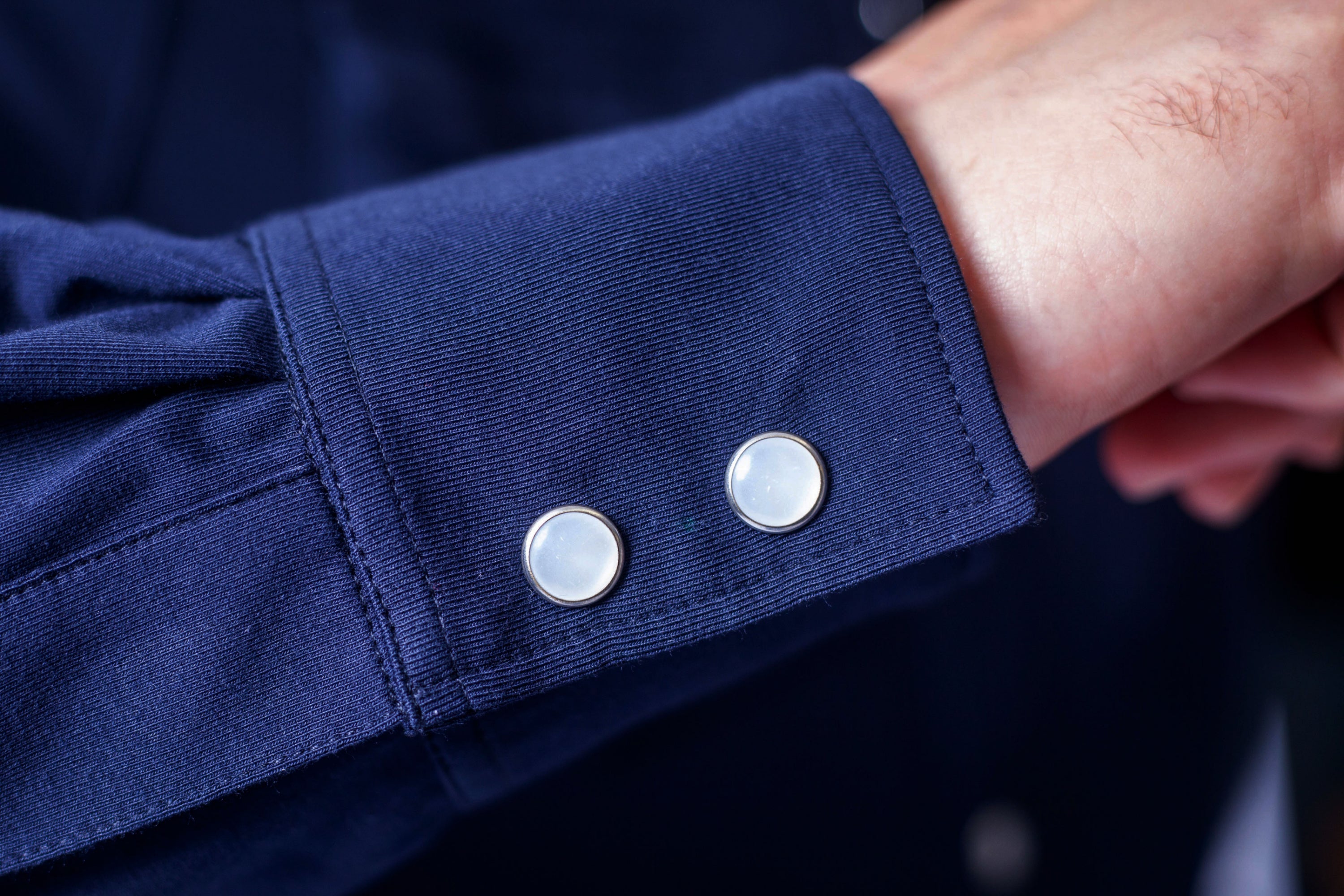 Navy Western tech shirt cuff with two snap-style buttons on sleeve end