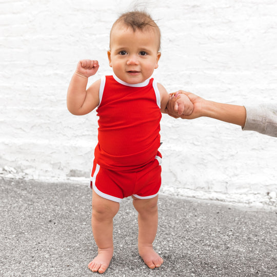 Red track shorts set with white trim—sleeveless tank and matching pull-on shorts