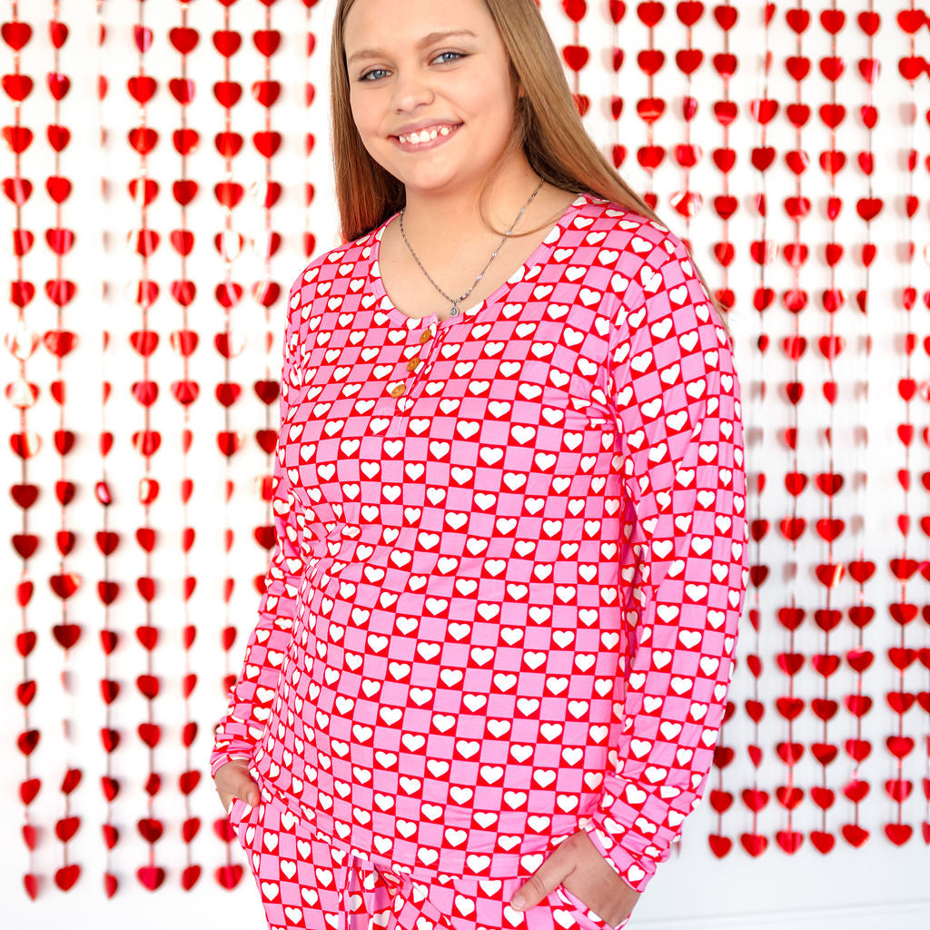 Women’s red heart pajama set on model, long-sleeve top and matching pants