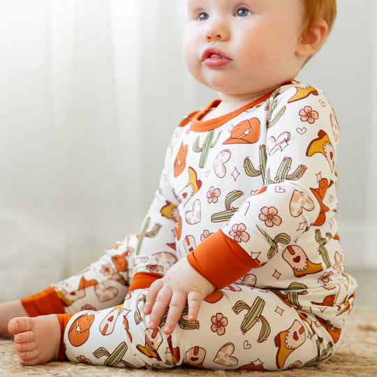 Two-piece long-sleeve baby set, white print with orange cuffs; cactus and fox pattern
