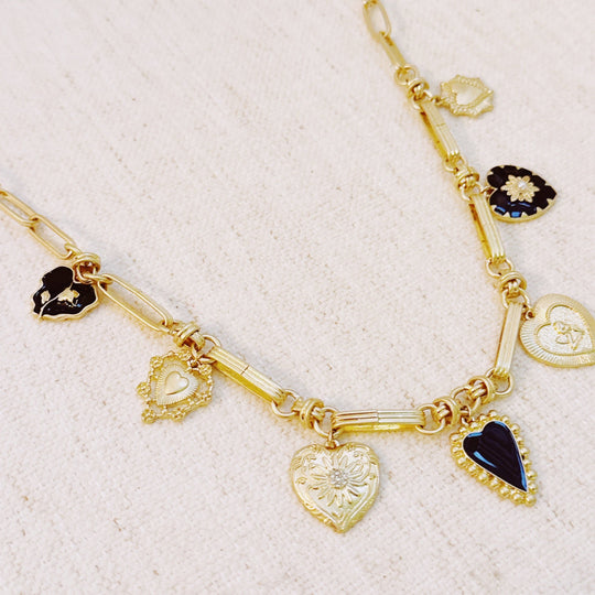 Gold-tone necklace with mixed black and gold heart charm pendants on a link chain
