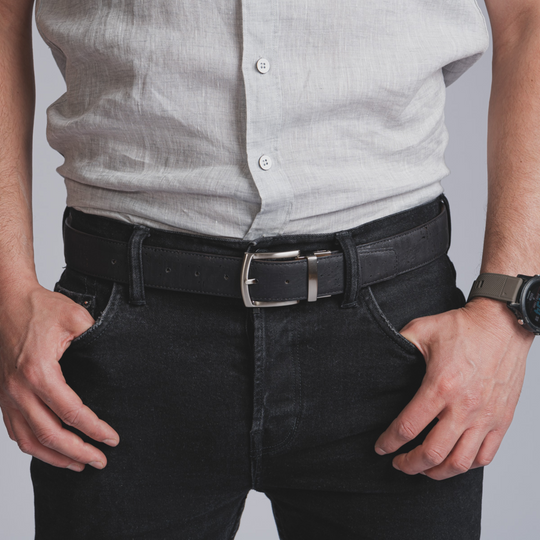 Black reversible cork men’s belt with silver buckle, worn on dark jeans