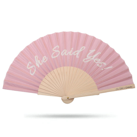 She Said Yes hand fan in pink, pleated fabric with wooden center and fan handle