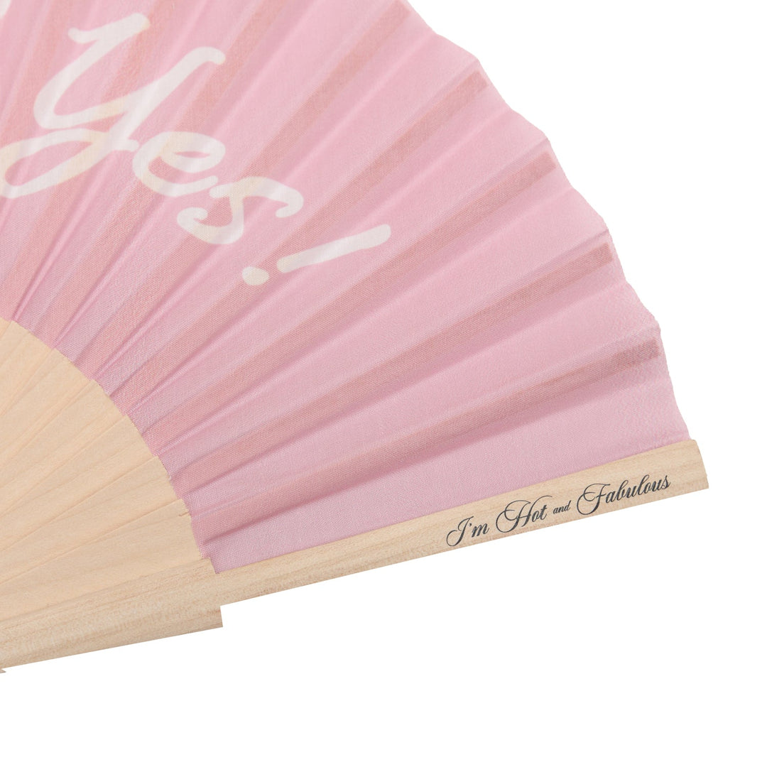 She Said Yes hand fan close-up: pink pleated fabric with script text on fan panel