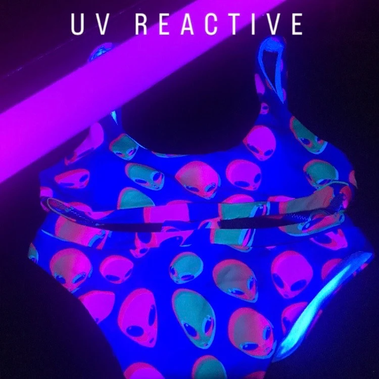 UV-reactive neon alien print bikini set, blue with multicolor faces glowing under UV