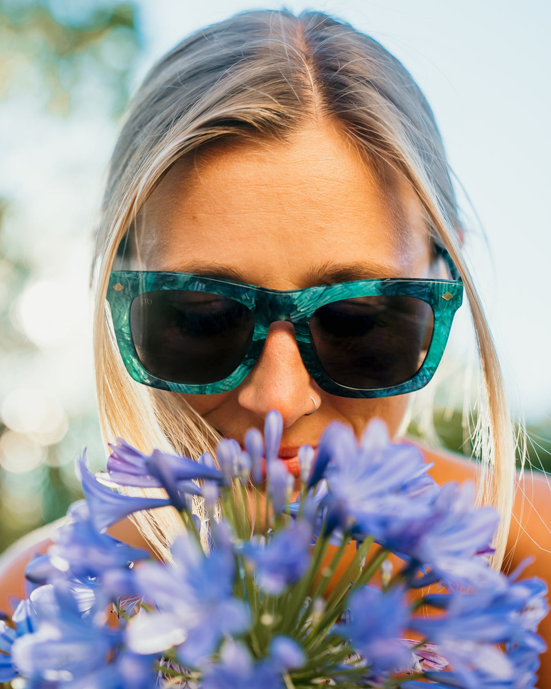 Devlin sunglasses on model, teal frame with dark tinted lenses