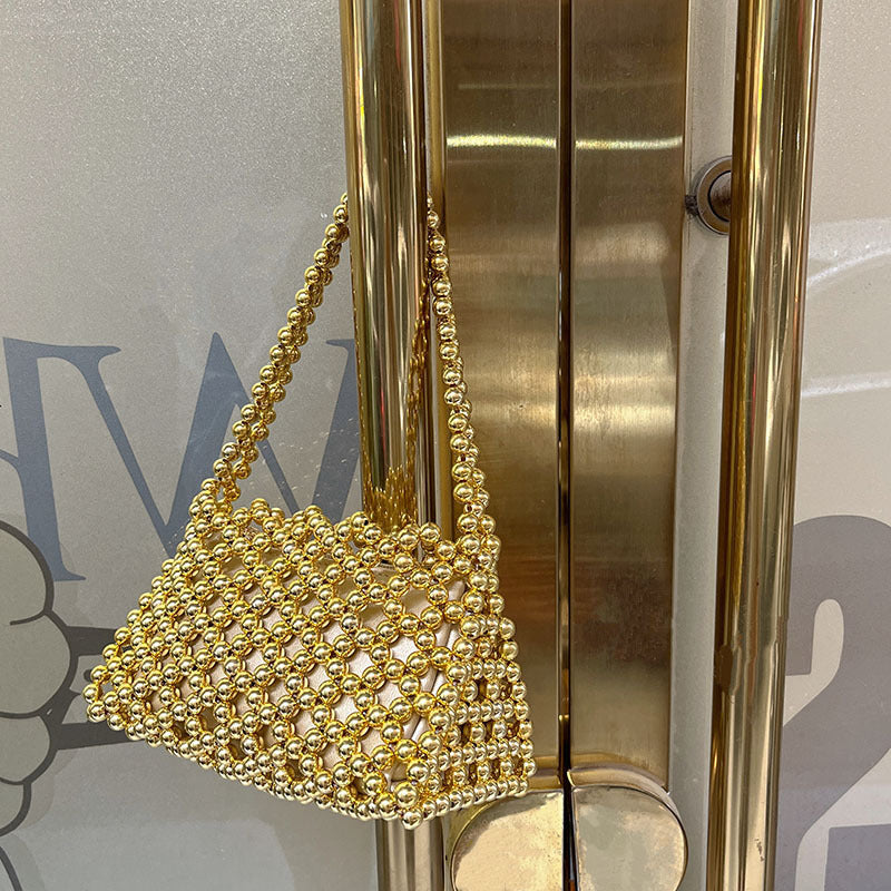 Gold beaded woven underarm bag with chain handle and rounded cutout
