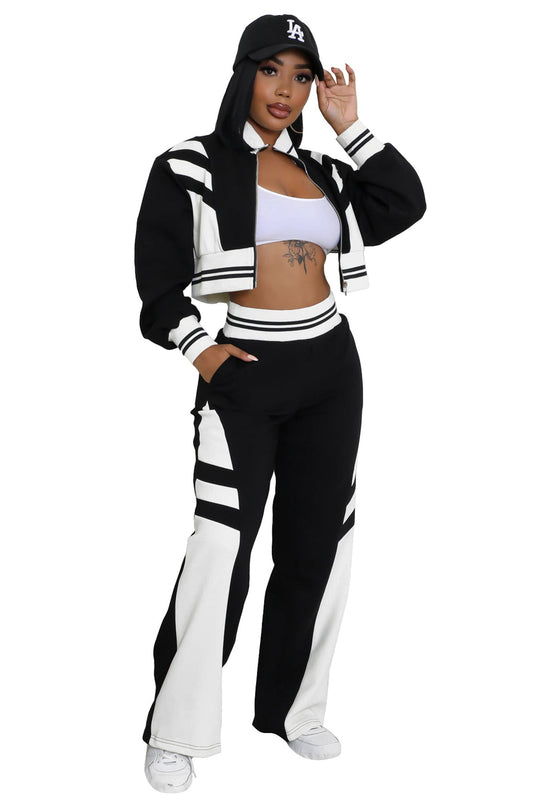 Black two-piece pant set with hooded jacket, striped waistband, and flare pants