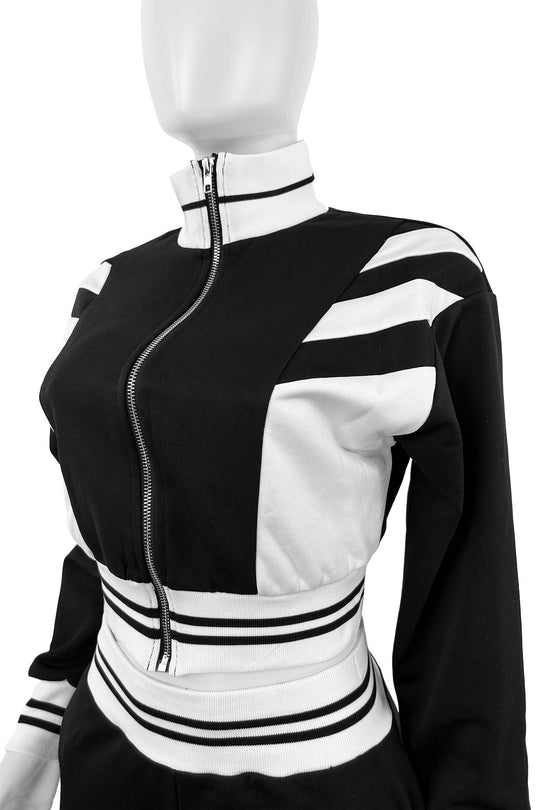 Close-up of black zip jacket: white stripe accents and ribbed striped waistband