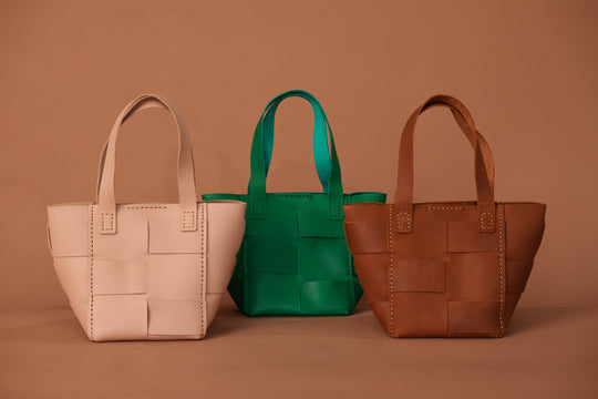 Basket totes in white, green, and camel brown; camel bag with front patch pocket