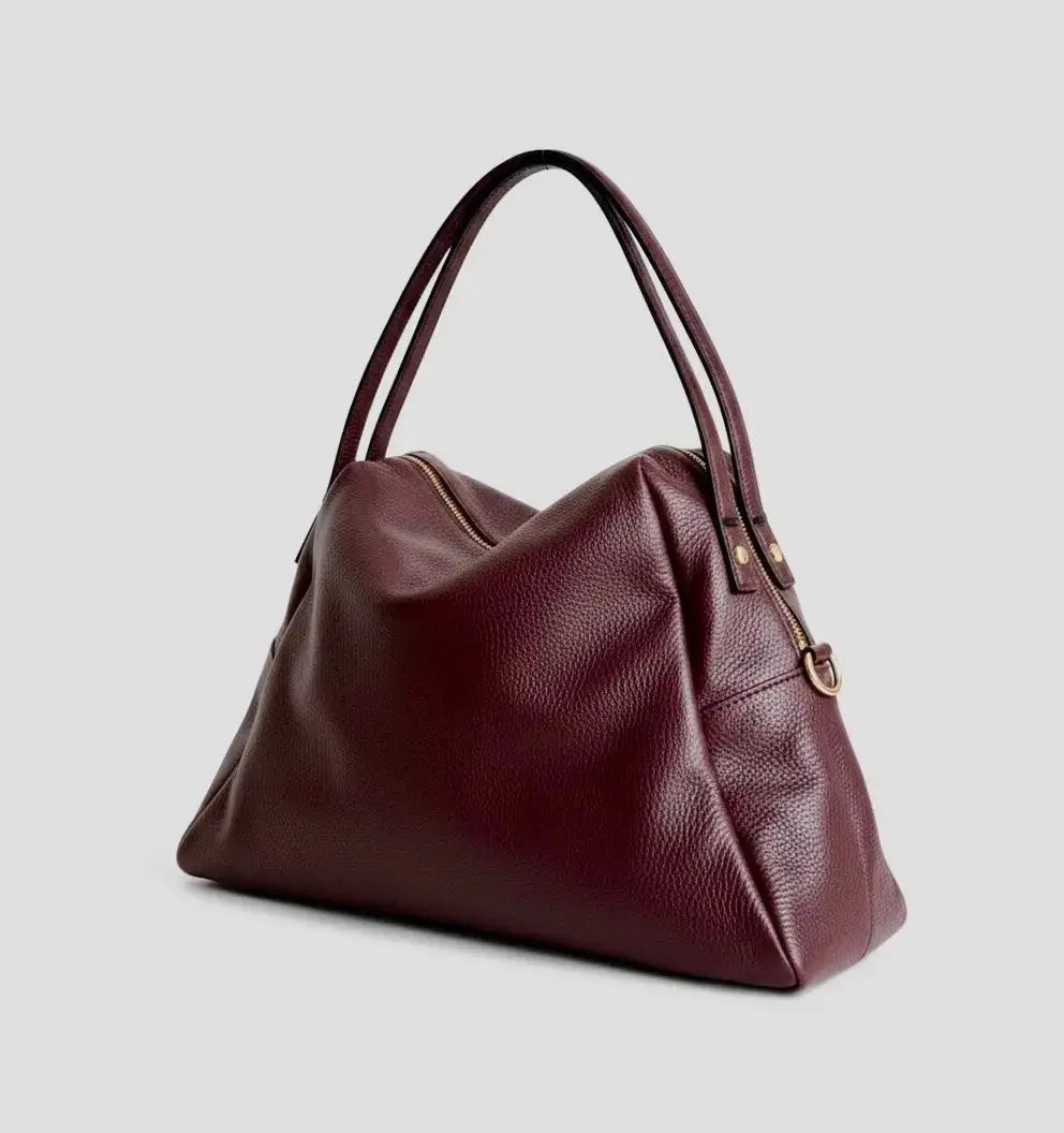 Merlot slouchy tote with zip top, curved front panel, and dual top handles