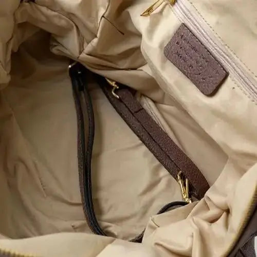 Slouchy tote interior view: fabric lining, zip pocket, and strap attachment