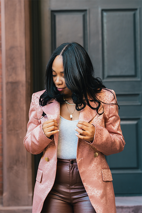 Blush blazer close-up with gold buttons and ornate print over the chest