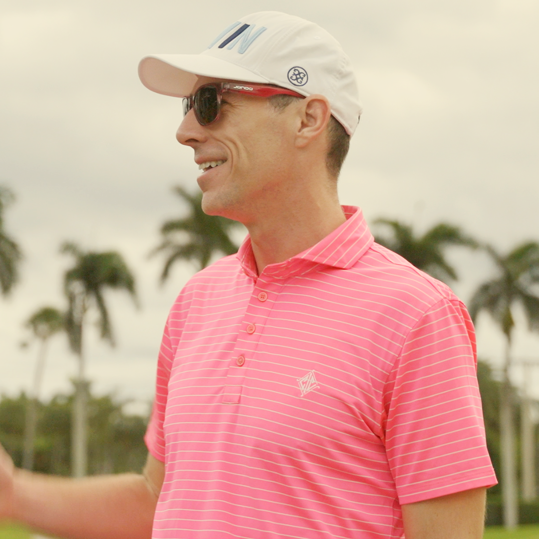 Pink Sandy Golf Sunglasses on a golfer, side profile with dark tinted lenses.