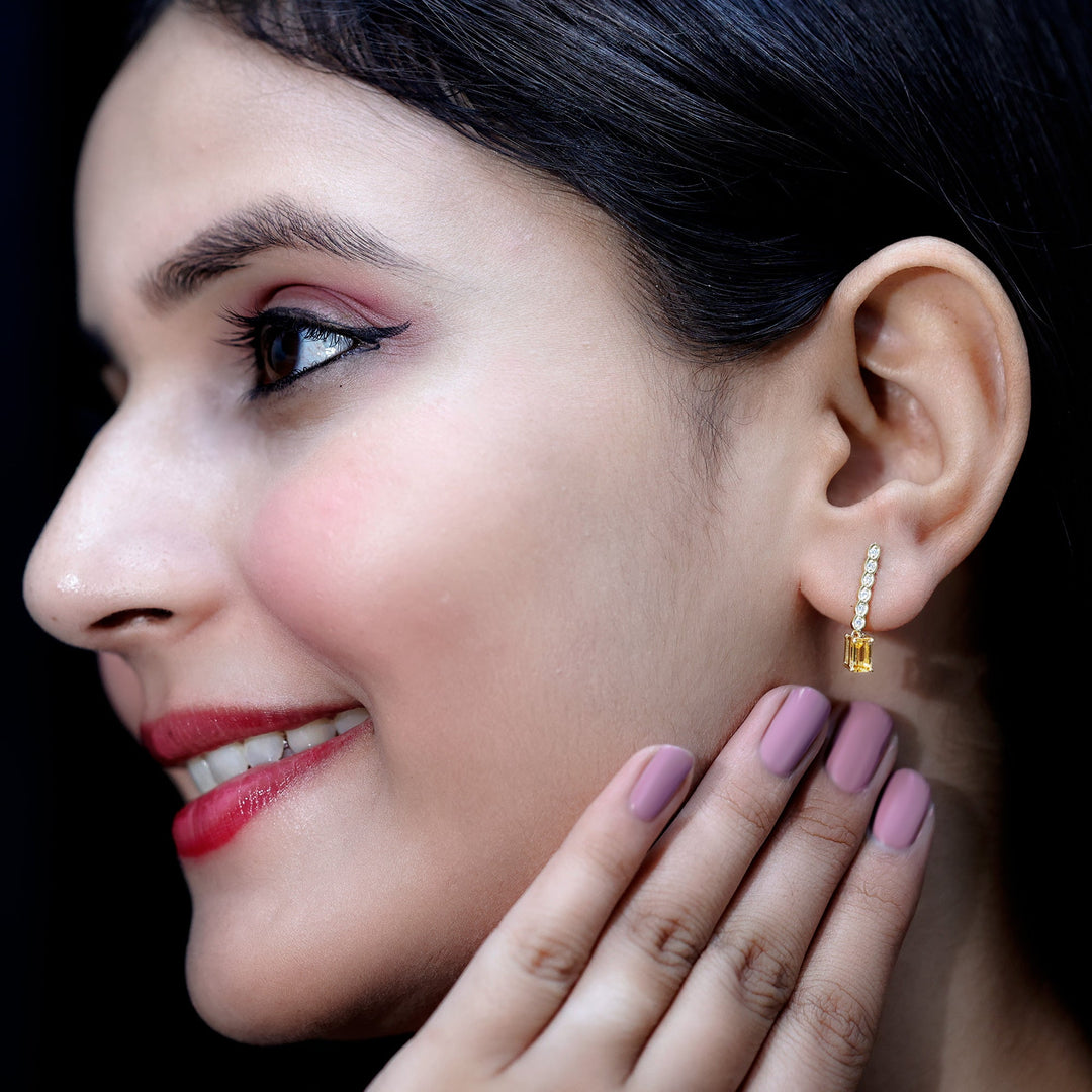 Gold-plated earrings featuring emerald-cut citrine with diamond bar drop on ear