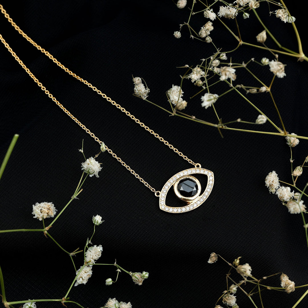 Gold-toned evil eye pendant necklace with dark center stone and outlined white pavé