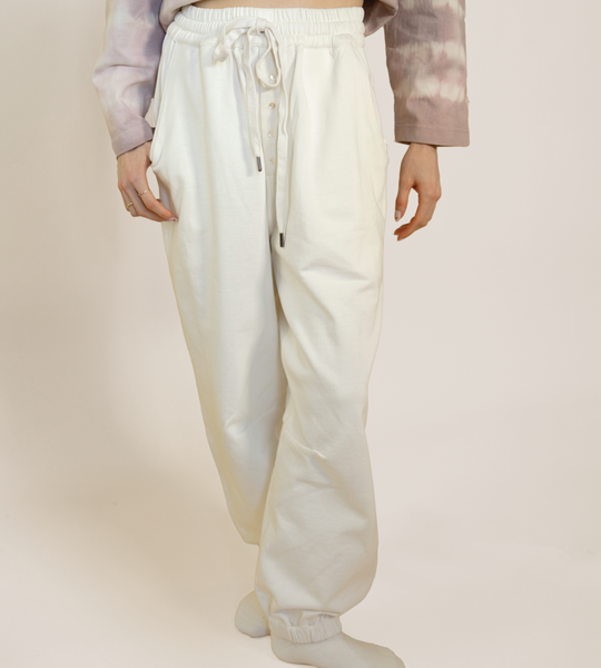 Off-white lounge pants with elastic waistband, drawcord ties, and side pockets