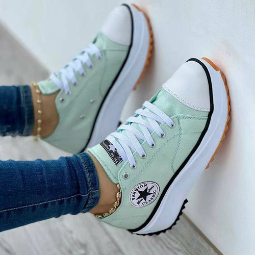 Light green canvas lace-up sneakers with white laces and white rubber sole