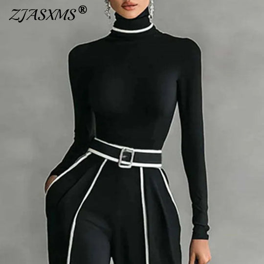 Black mock-neck top with stand collar and belt; wide-leg trousers with white stripe trim