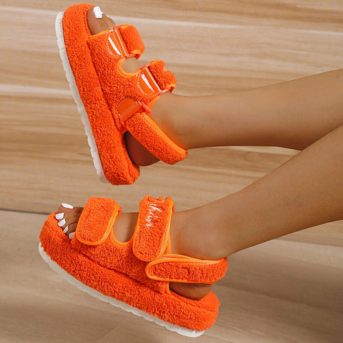 Orange thick-bottom women’s sandals with plush straps and open-toe design.