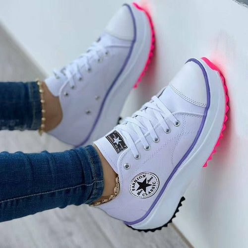 White lace-up canvas casual sport sneakers with red-accent outsole and logo patch