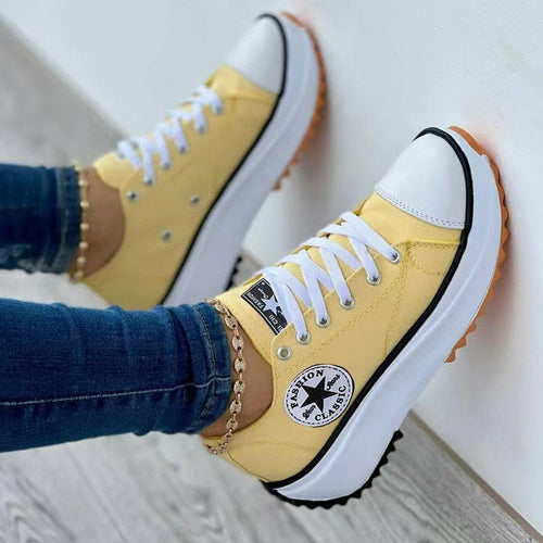 Yellow lace-up canvas sneakers with white laces and side logo patch