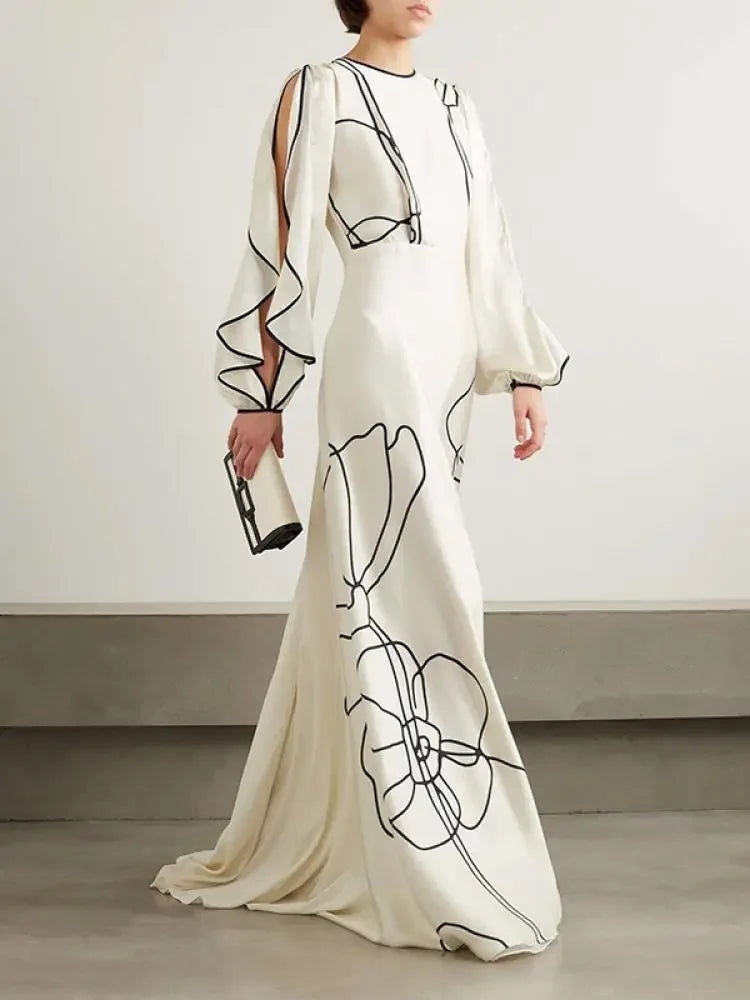 White maxi evening dress with black floral line print, long draped sleeves, floor length