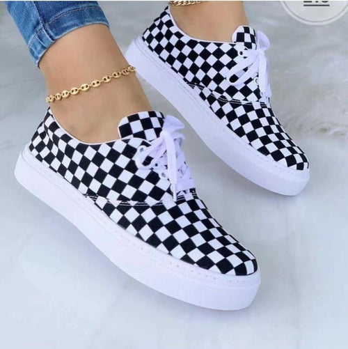 Women’s graffiti sneakers with black-and-white check pattern and white lace-ups