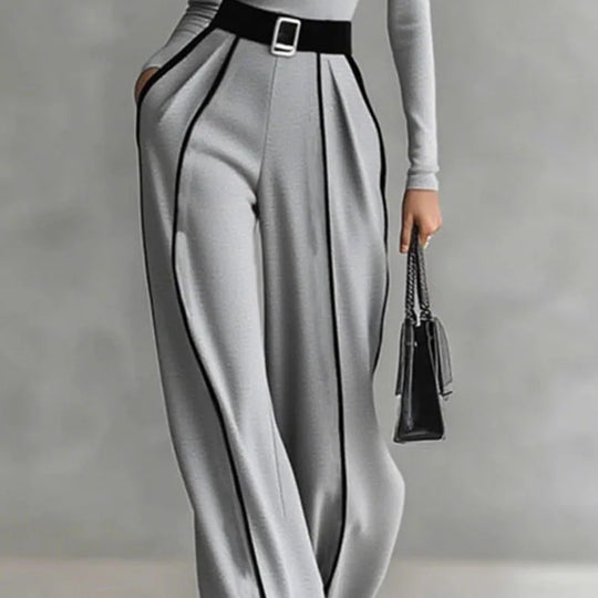 Gray wide-leg trousers with pleated panel lines and black belt; mock-neck top