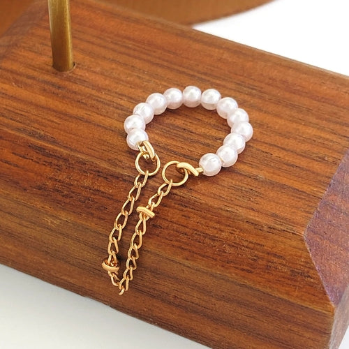 White pearl beaded bracelet with gold-tone chain and heart charm links