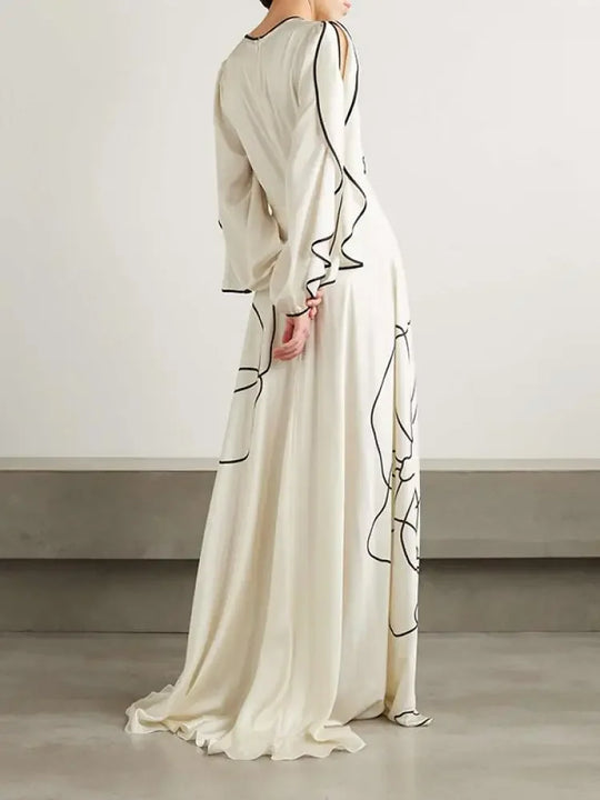 White maxi dress with black floral line print, draped sleeves, side/back view